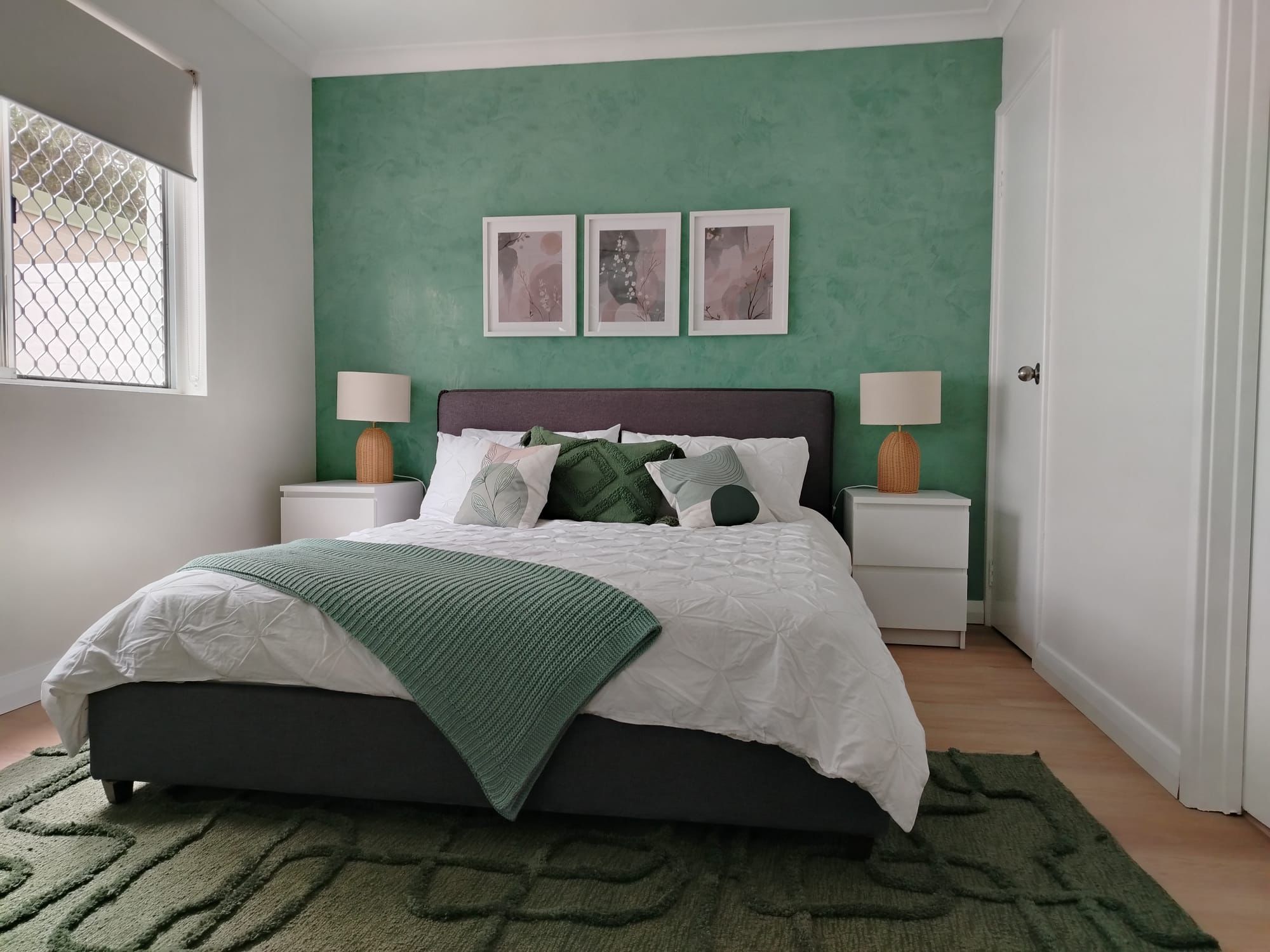 Green venetian plaster feature wall in a styled bedroom interior
